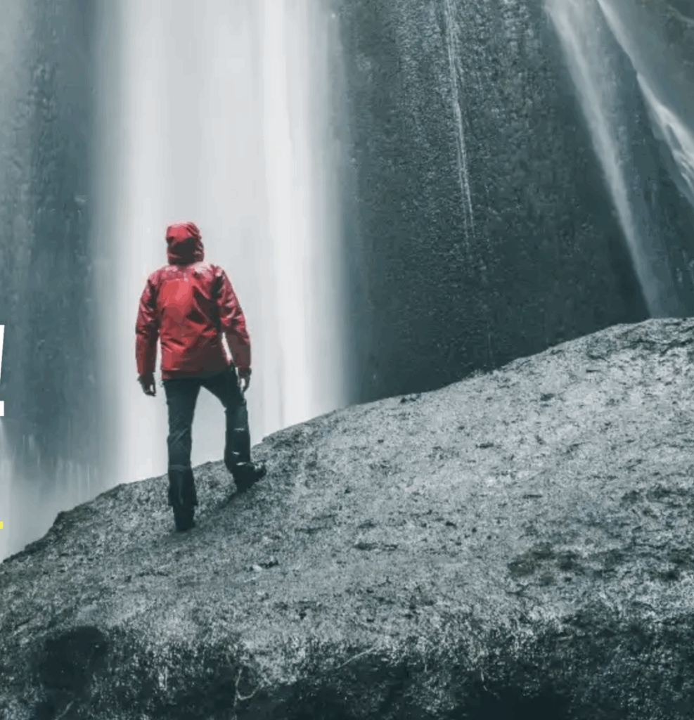 Statuslevel Loyalty Programm: Person in roter Jacke vor mächtigem Wasserfall